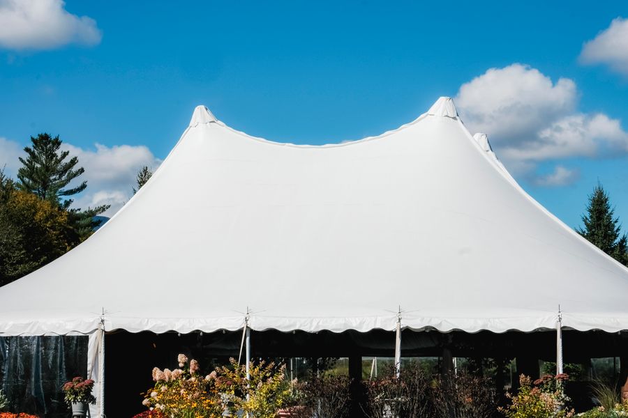 A plain white event tent set up outdoors